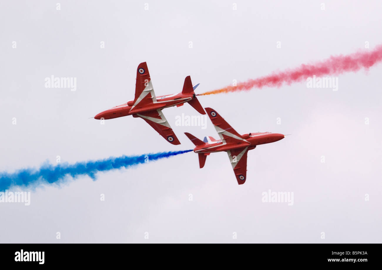 Two Royal Airforce Red Arrows Hawk T1 jet aircraft are pictured as they perform a flypast during a display in Gloucestershire, England. Stock Photo
