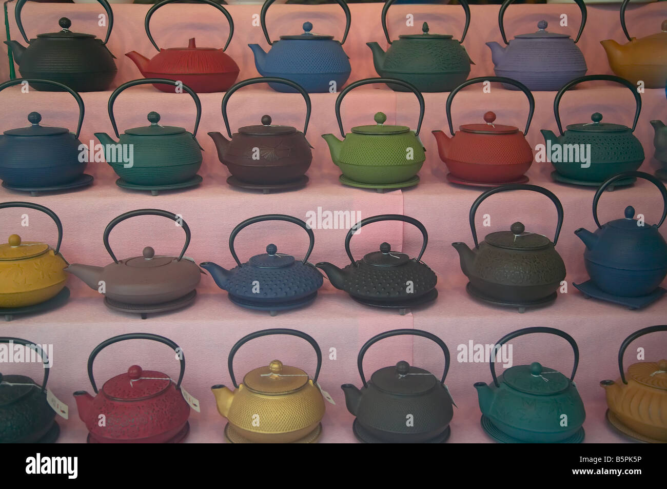Teapots with price tags for sale in a store window display. Stock Photo