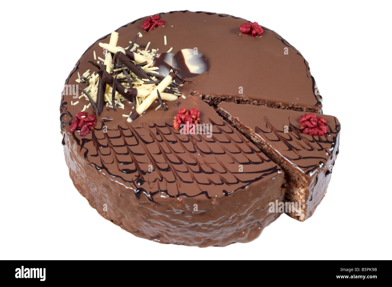 Cut birthday cake with walnuts and decoration on white background. Stock Photo