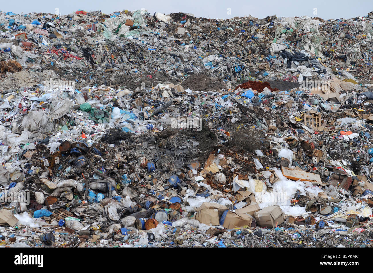 Various rubbish and trash heaped on a slope of municipal dump. Stock Photo