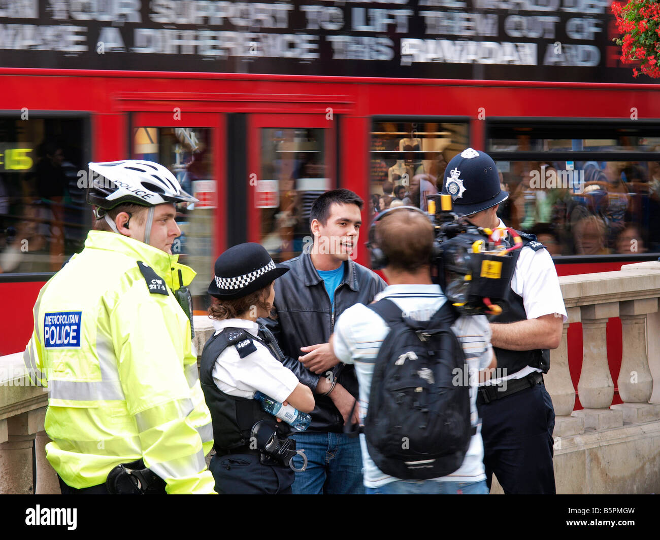Police officers with apprehended suspect and news cameraman on Oxford Circus London UK Stock Photo