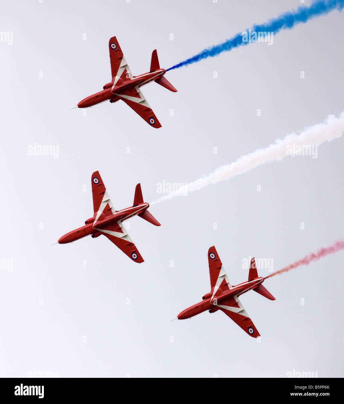 Three Royal Airforce Red Arrows Hawk T1 jet aircraft are pictured as they perform a flypast during a display in Gloucestershire, England. Stock Photo