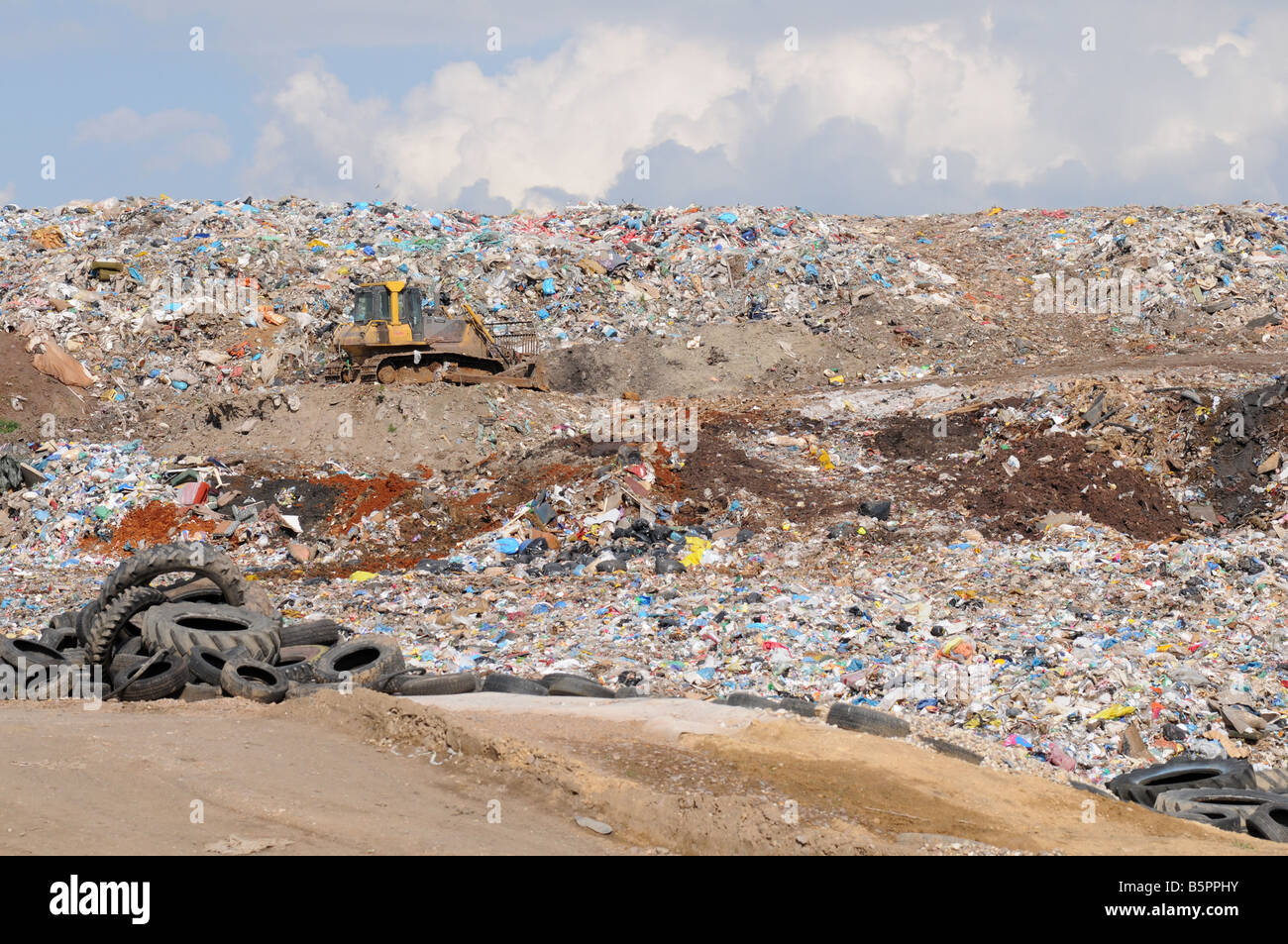 Bulldozer on a heap of rubbish and trash on a dump Stock Photo Alamy