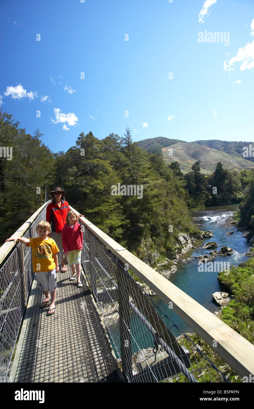 Family on Suspension Bridge across Rai River at Pelorus Bridge Marlborough South Island New Zealand Stock Photo
