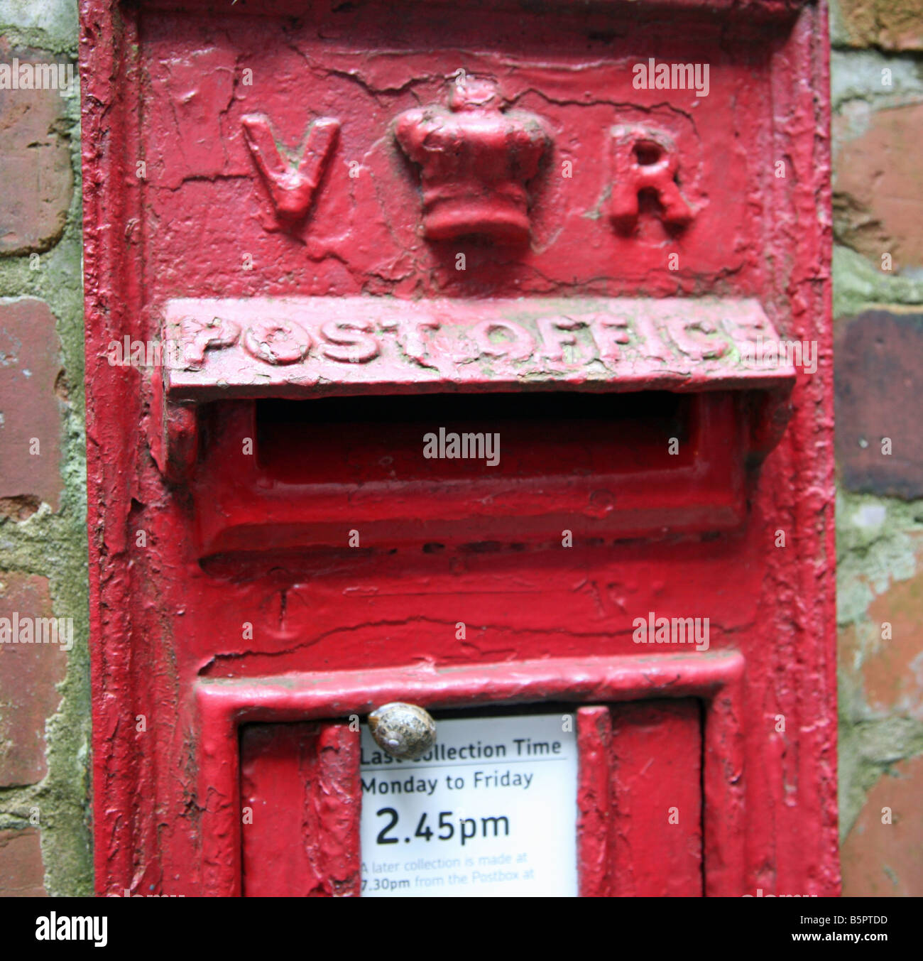 A Victorian post box with a snail crawling up it Stock Photo