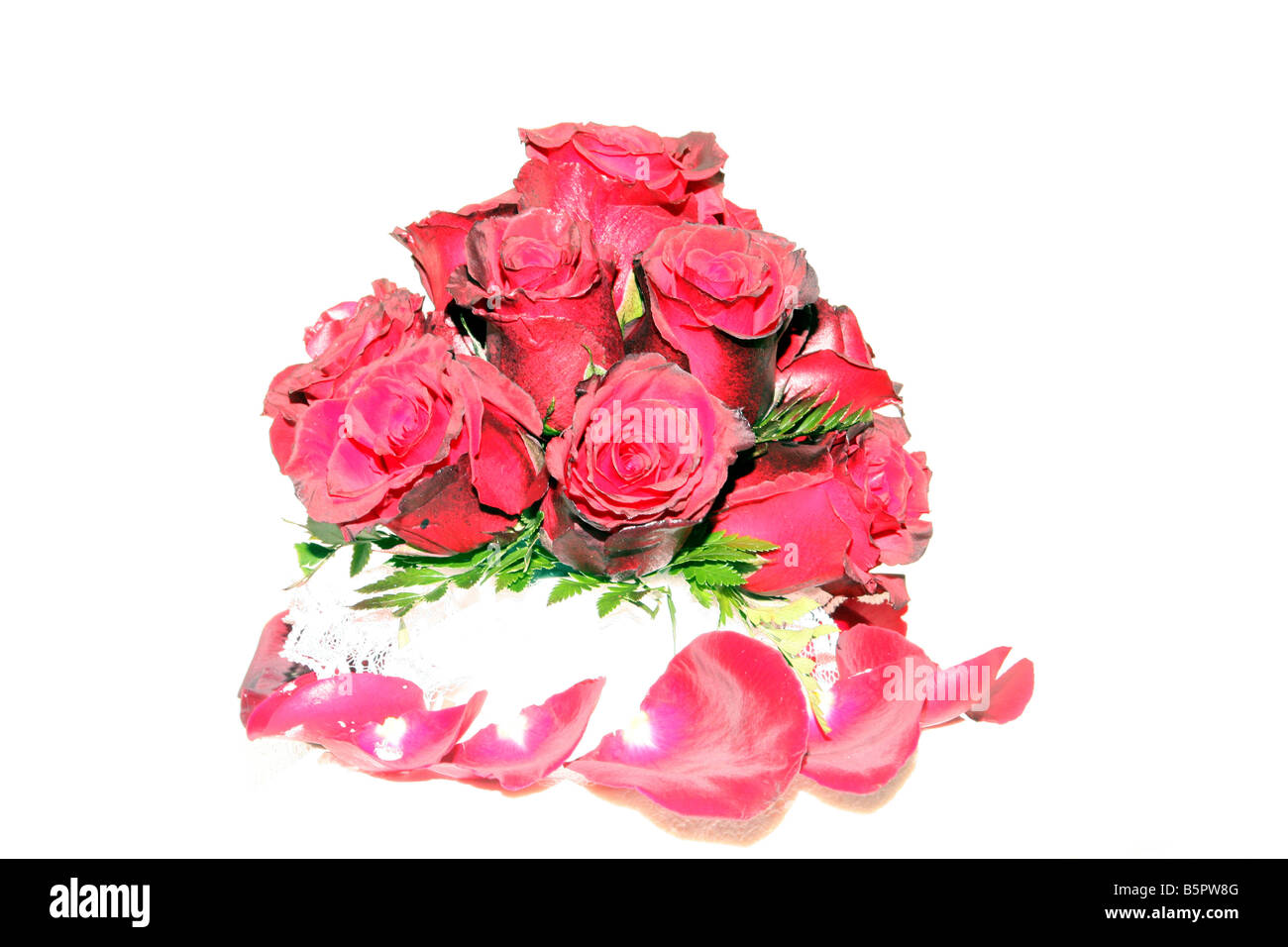A fancy wedding cake with red roses on top displayed for a wedding reception Stock Photo
