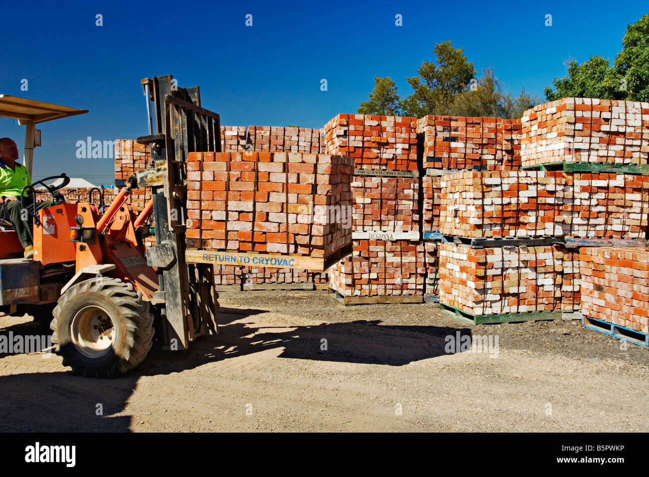 Building Materials / A Forklift Driver stacks used Bricks in a