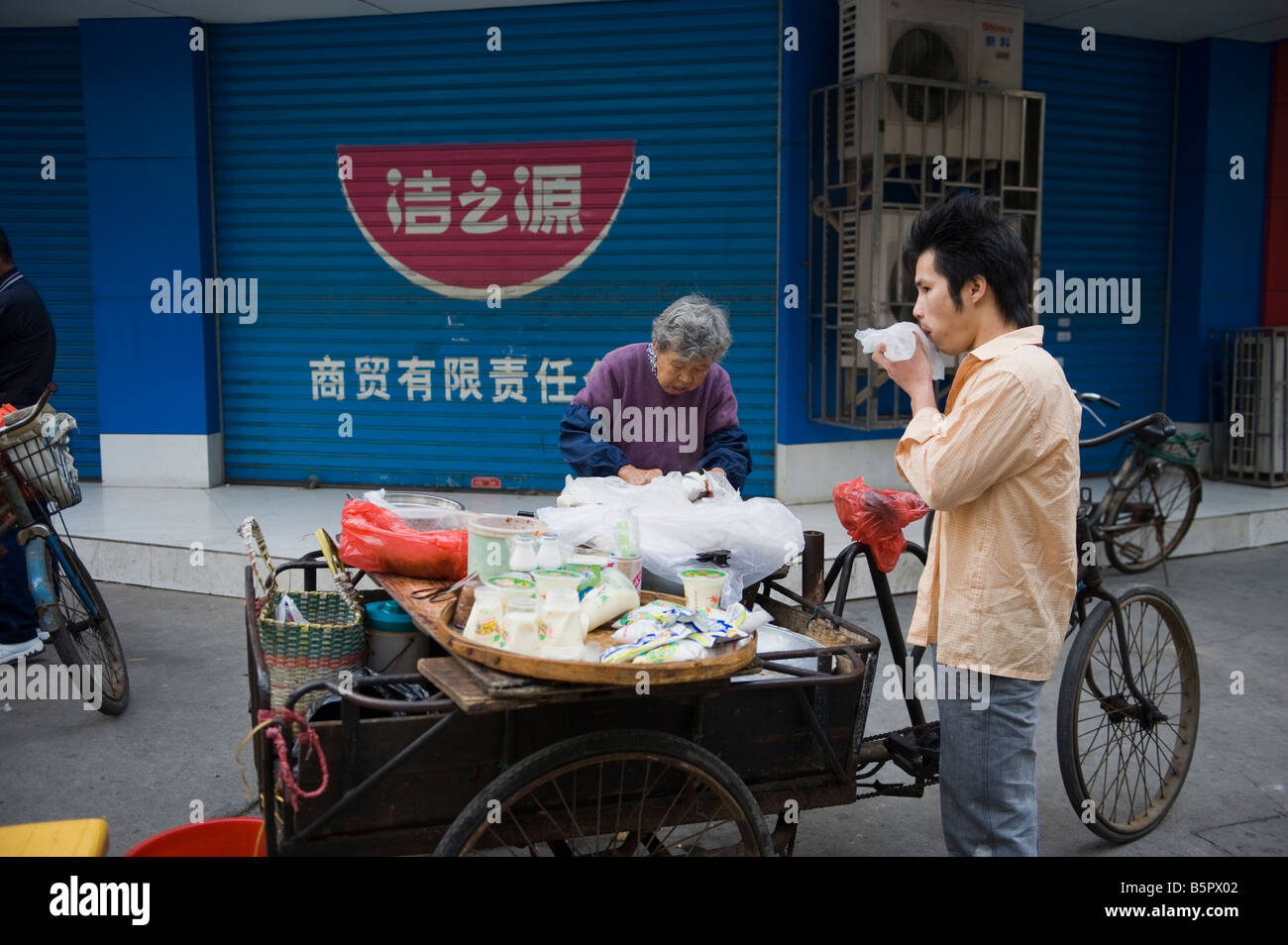 Chinese man buy daily food in street market in guilin hires stock