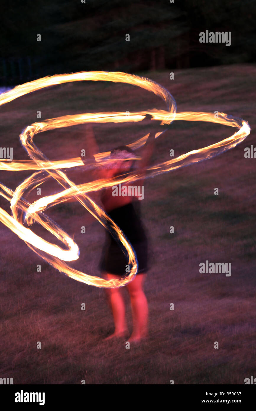 The glow of a female Hawaiian Fire Dancer performing at night Stock Photo