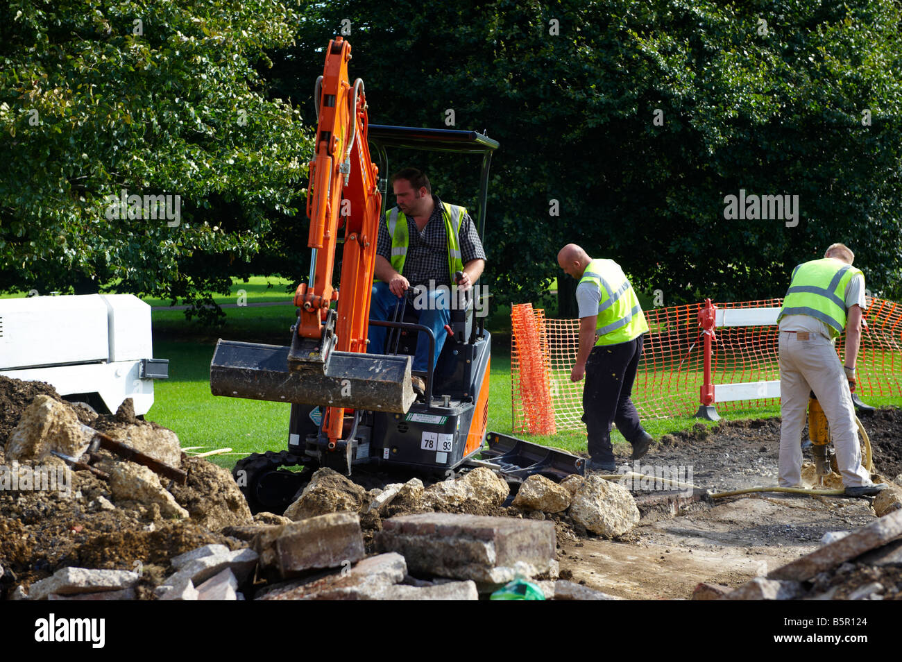 Workers digging with digger machinery Cambridge UK Stock Photo
