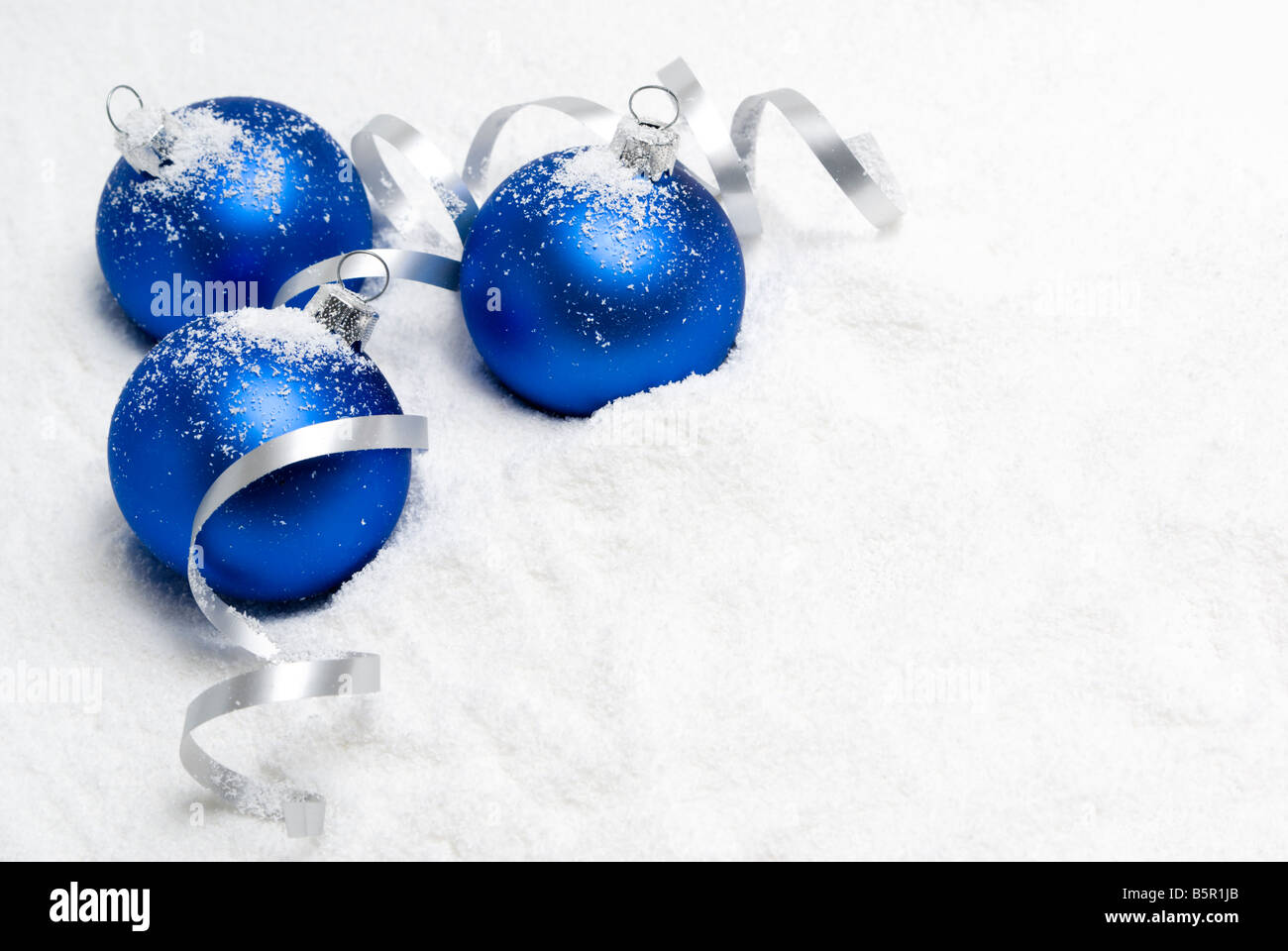 Blue christmas balls lying on the snow. aRGB. Stock Photo