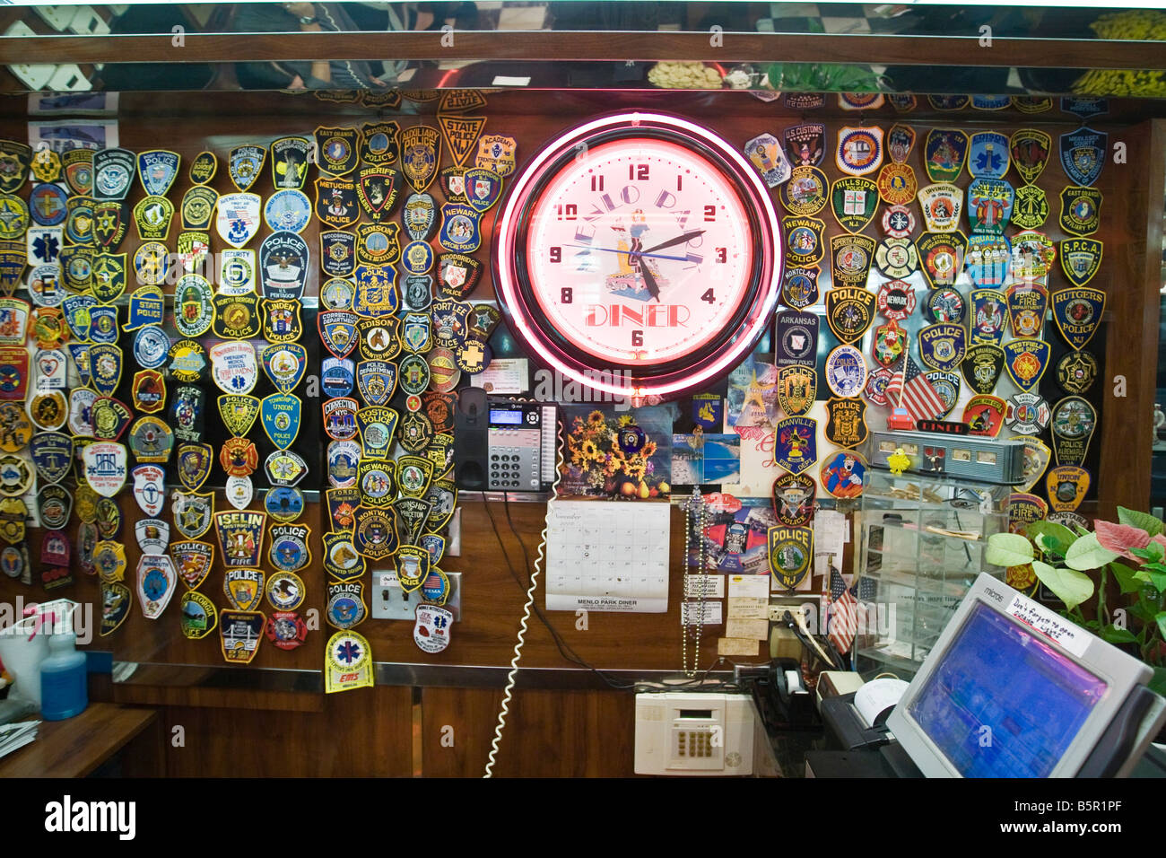 Police and emergency services badges on a wall in a diner Stock Photo