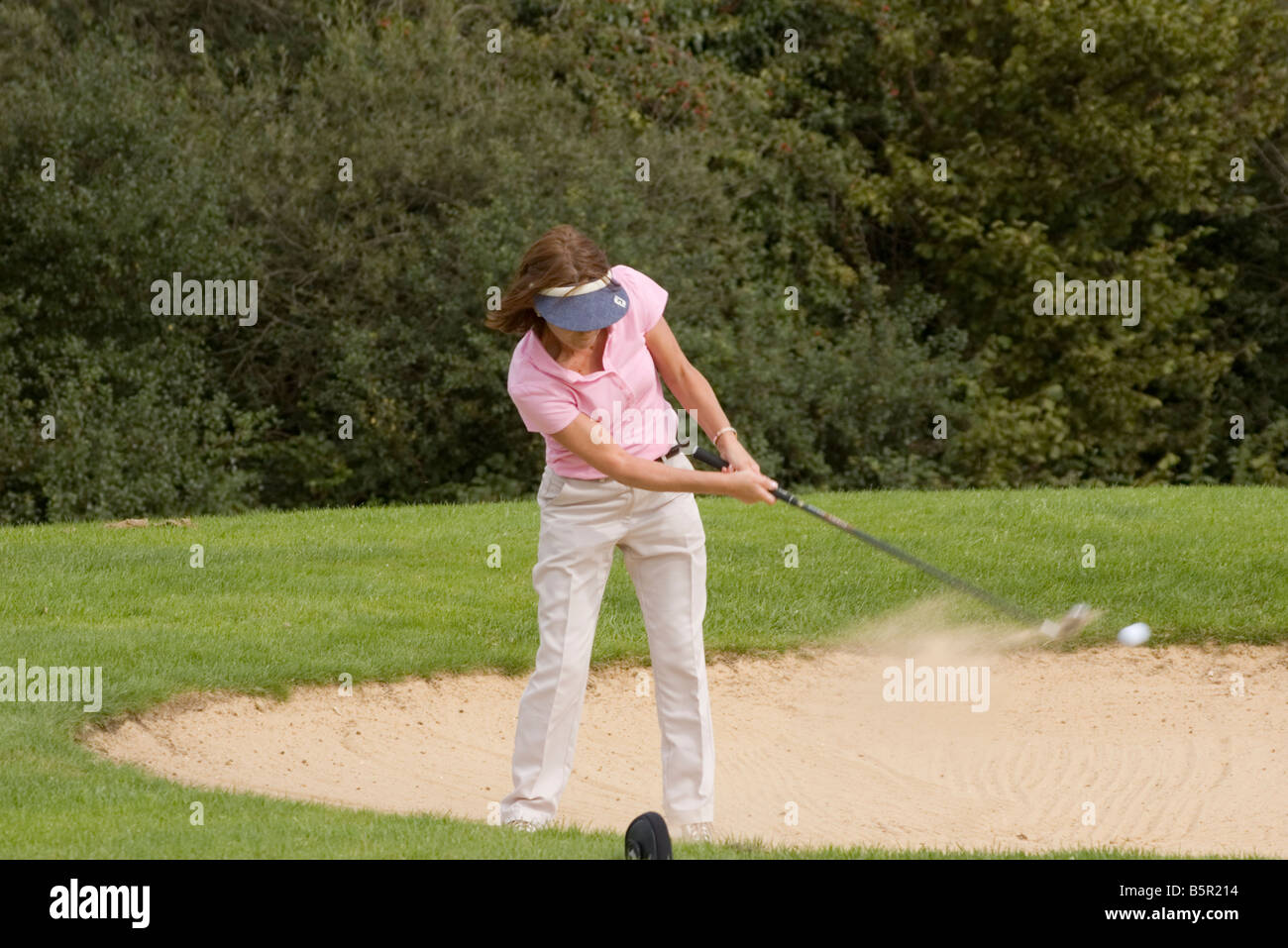 Lady Female Woman person Golfer Playing a Bunker Shot Stock Photo