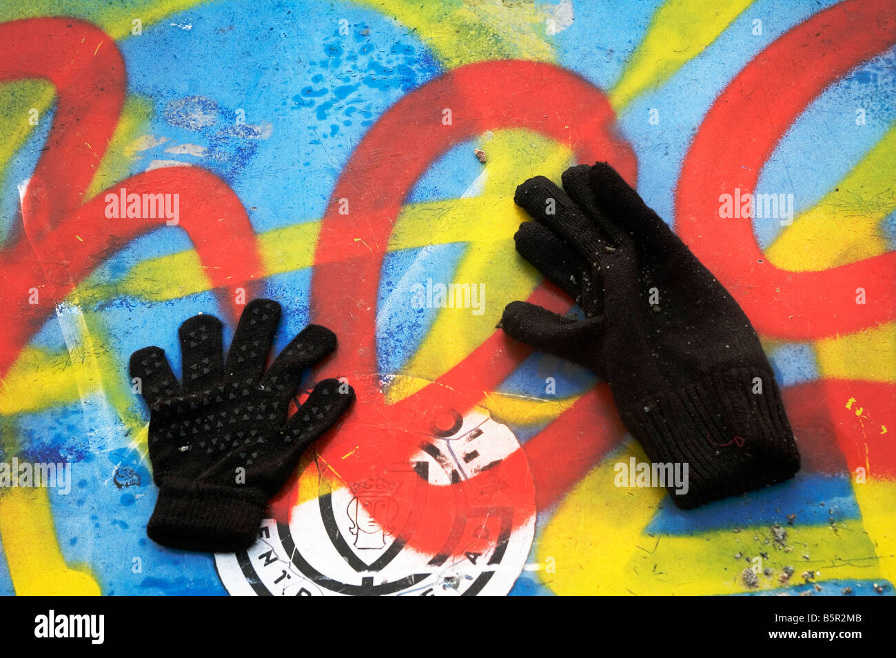Lost mittens found and placed on a graffiti painted blue sandbox Stock Photo