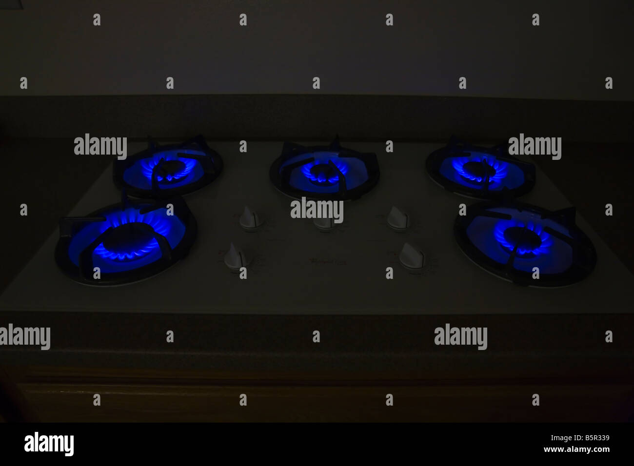 Lit natural gas stove burners on cooktop Stock Photo Alamy