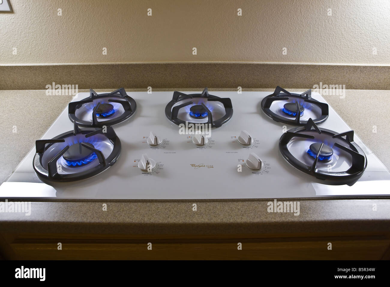 Lit natural gas stove burners on cooktop Stock Photo Alamy