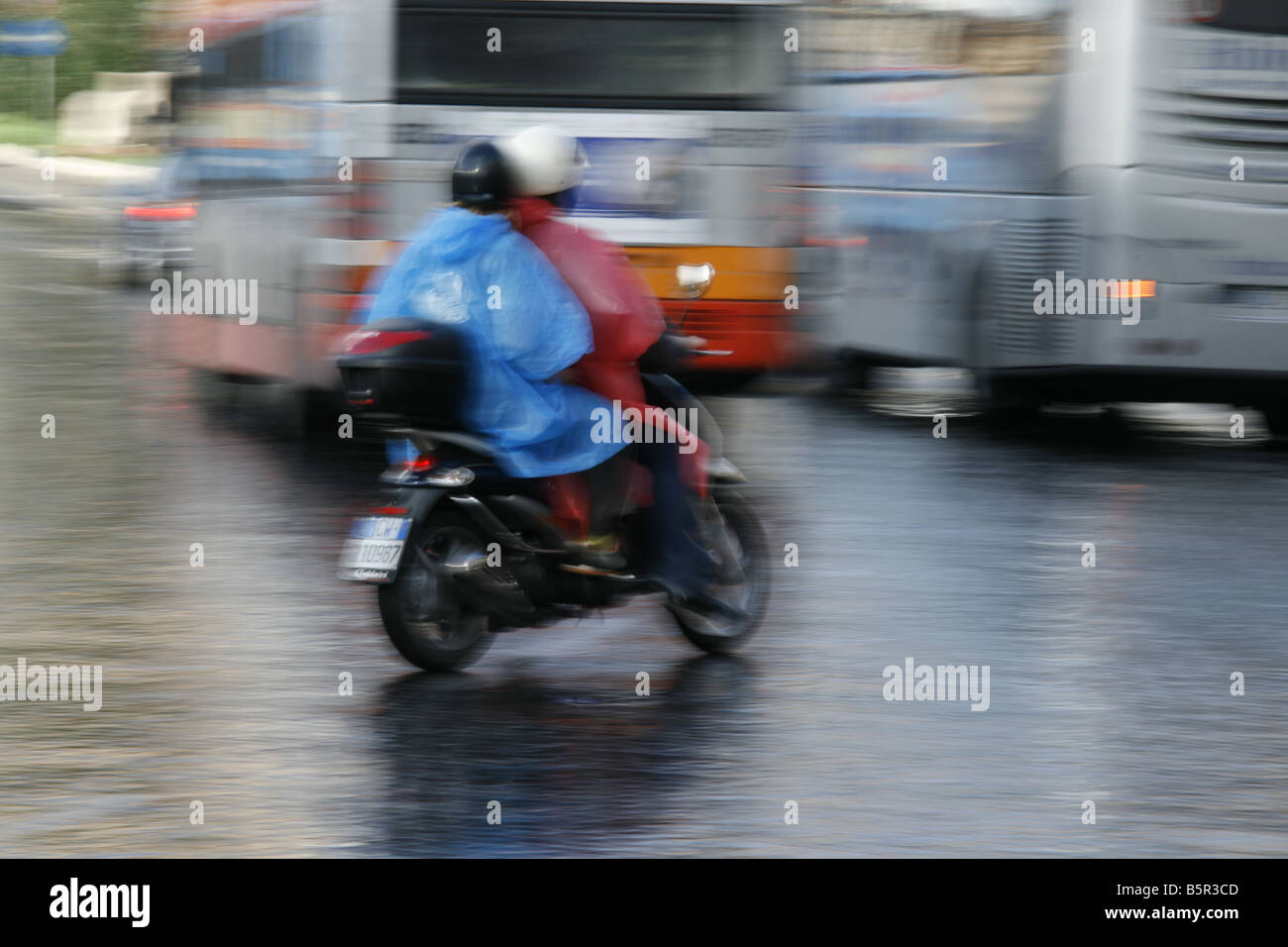 group young tourists riding rental hire scooters mopeds in rain in rome