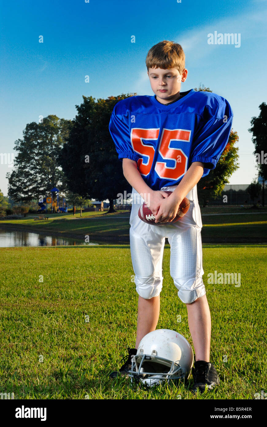Young football player holding the ball and thinking Stock Photo