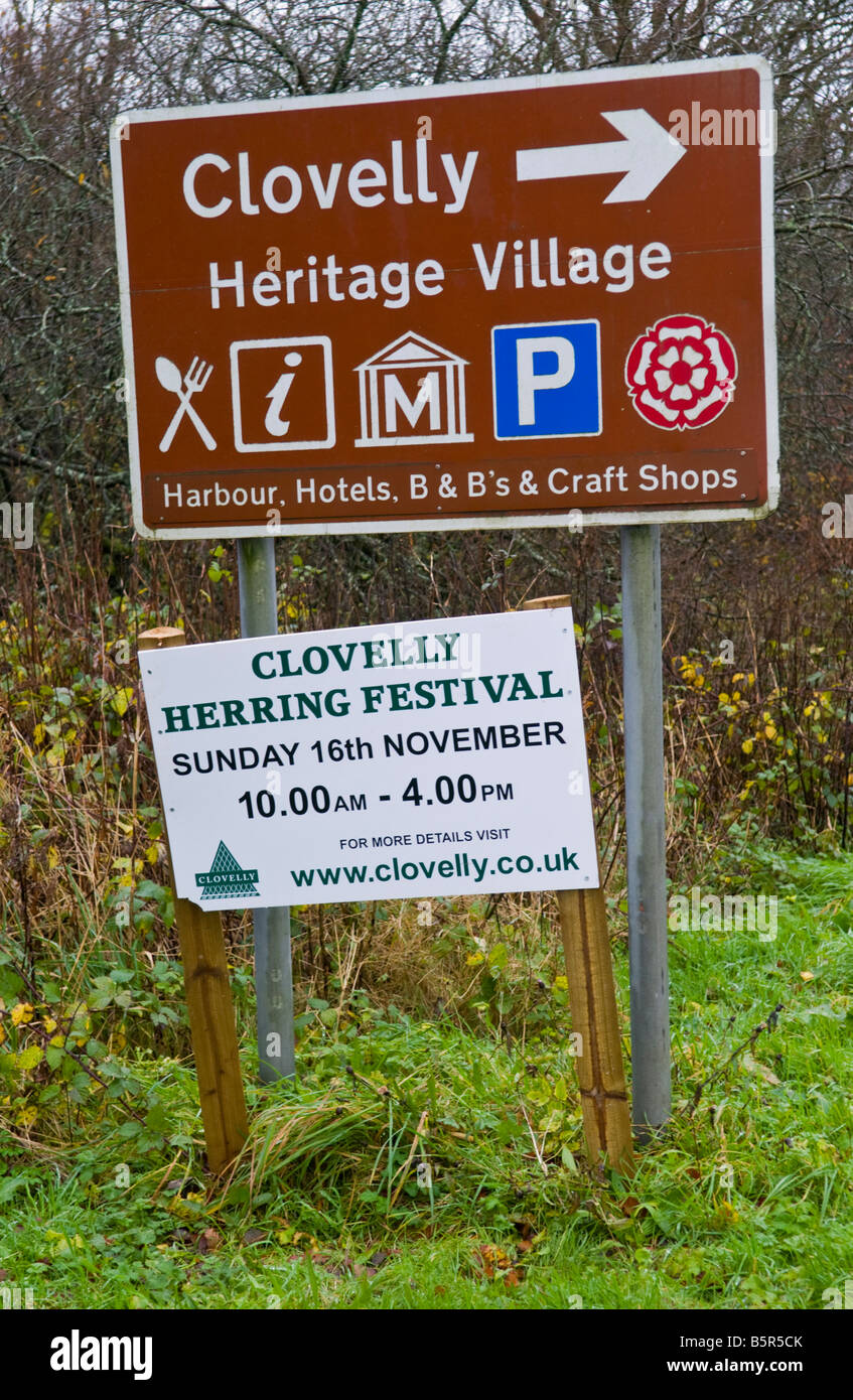 Brown tourist road sign for the coastal village of Clovelly North Devon England UK with sign for annual Herring Festival Stock Photo