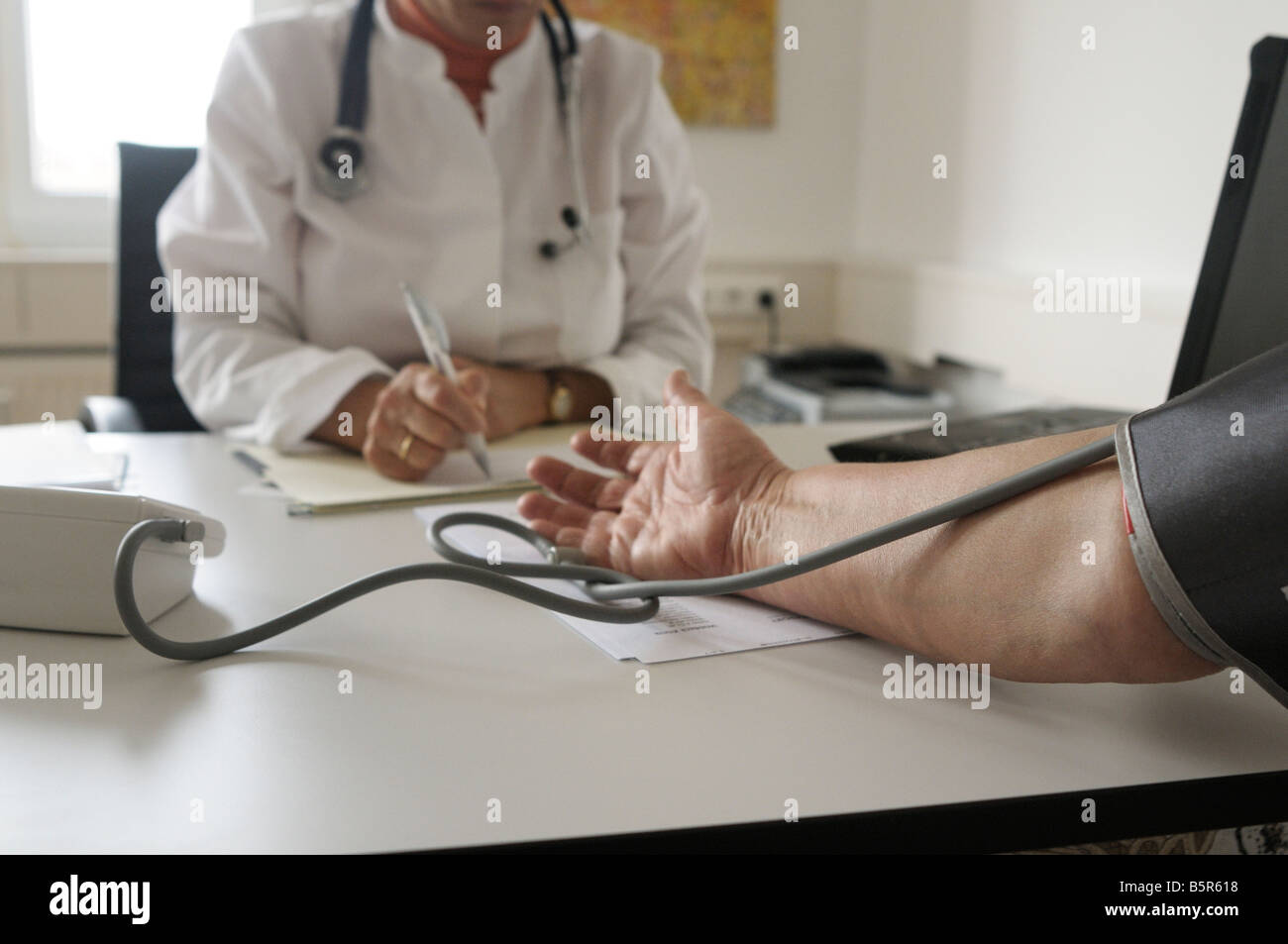 Female doctor examines the blood pressure of elderly patient Stock Photo
