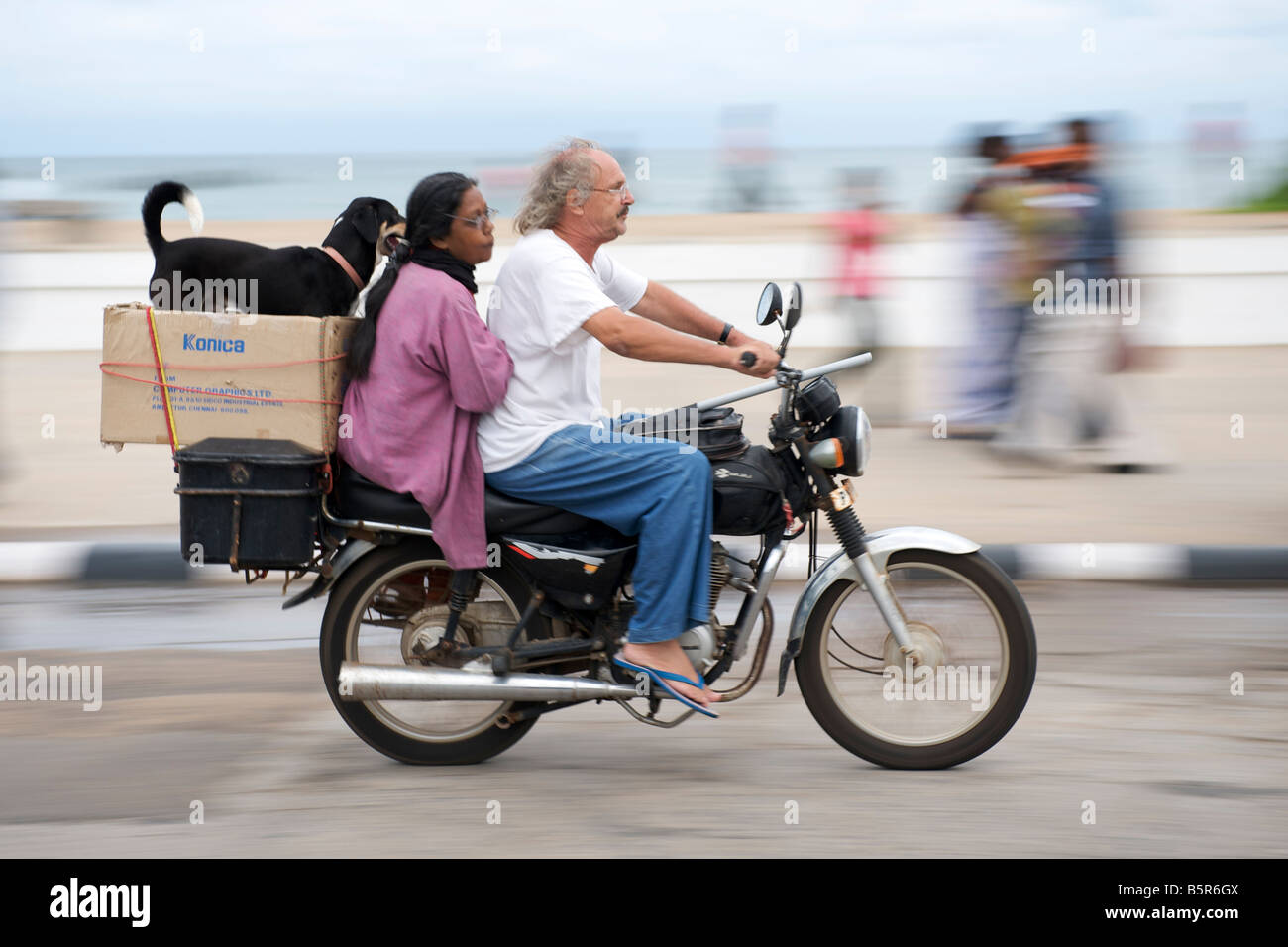 Motorcyclist and passengers on the Pondicherry waterfront in India. Stock Photo