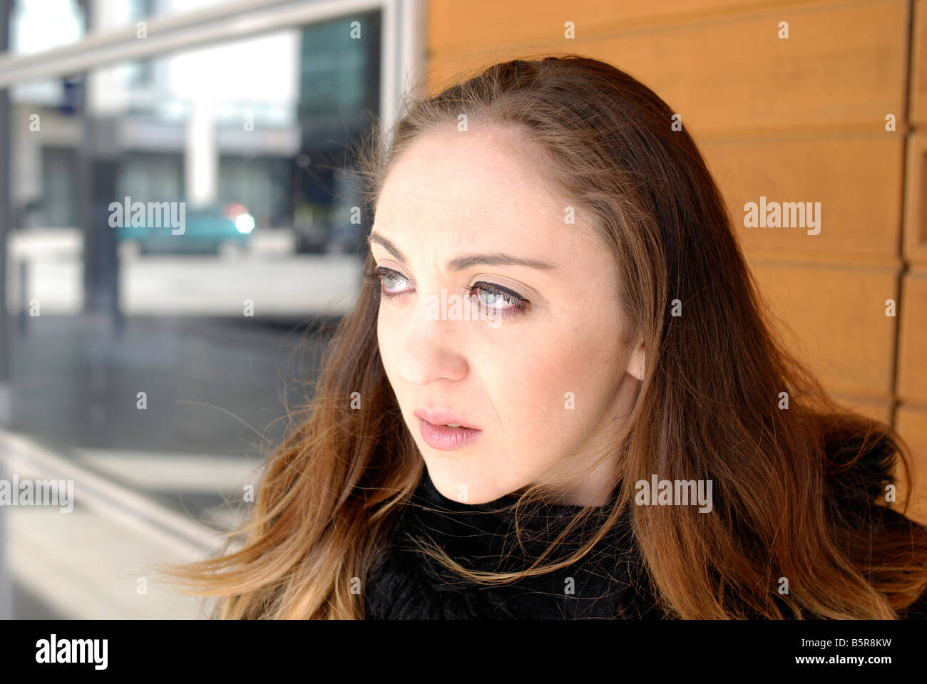 A young woman looking around her as she walks in the city Stock Photo