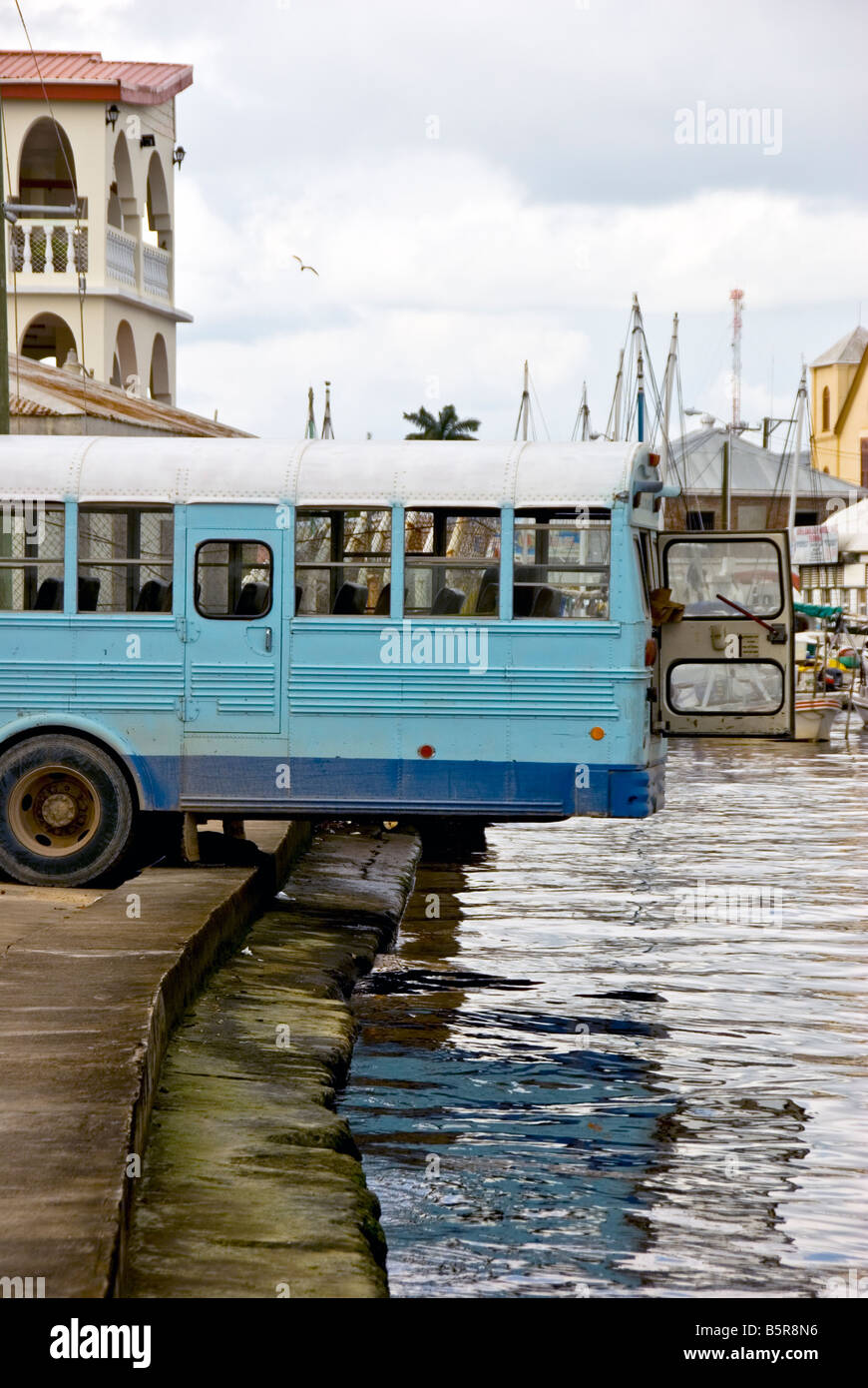 Belize City humor bus backed over river for better air flow in precarious situation Stock Photo
