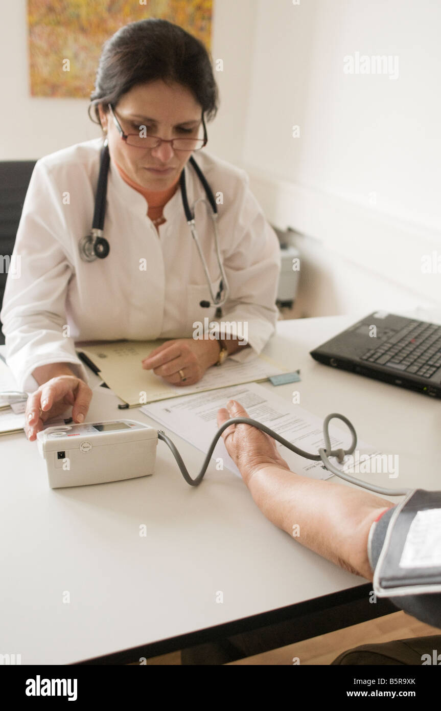 Doctor checks patients blood pressure Stock Photo - Alamy