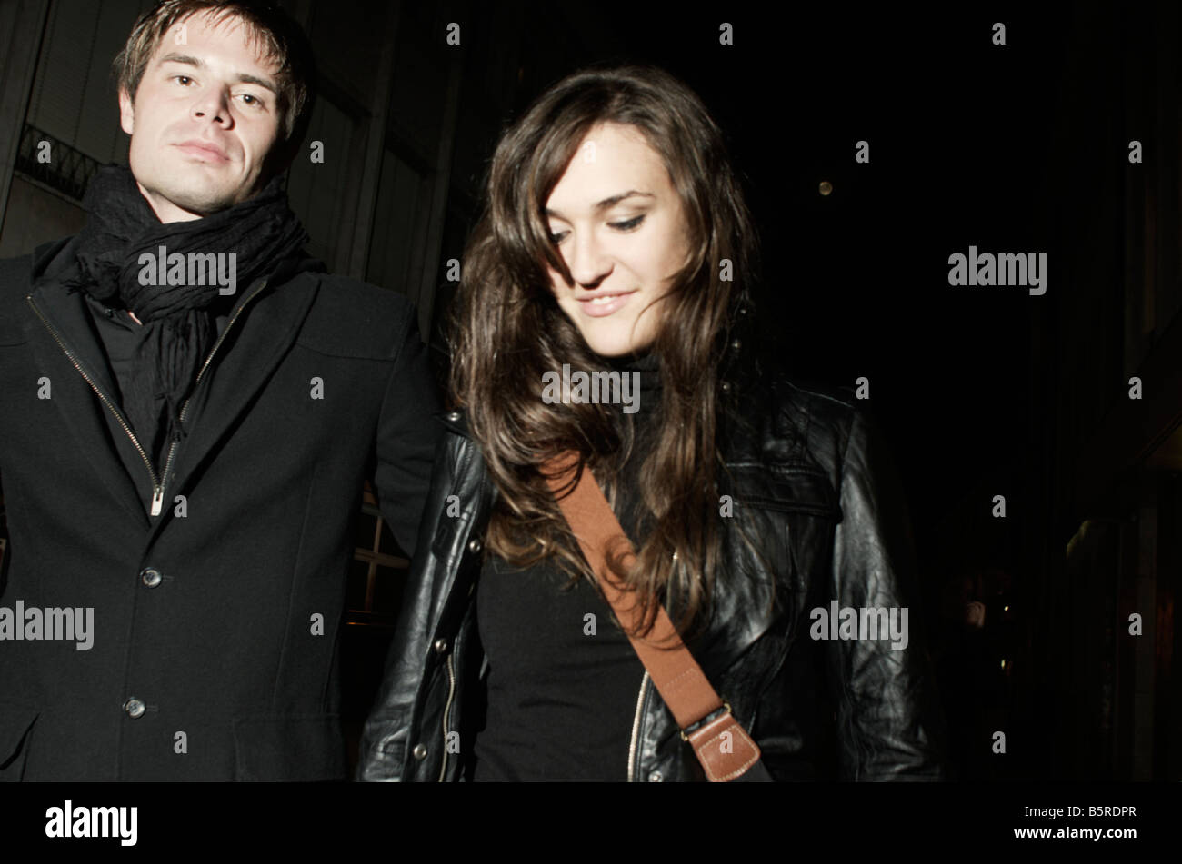 Young couple walking the streets at night Stock Photo - Alamy