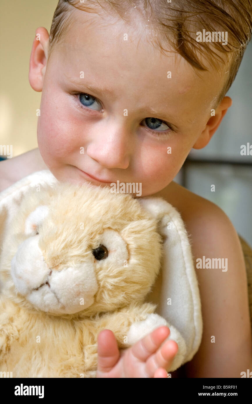 Cuddle With Toy Rabbit Young boy cuddling a plush toy rabbit Stock Photo - Alamy