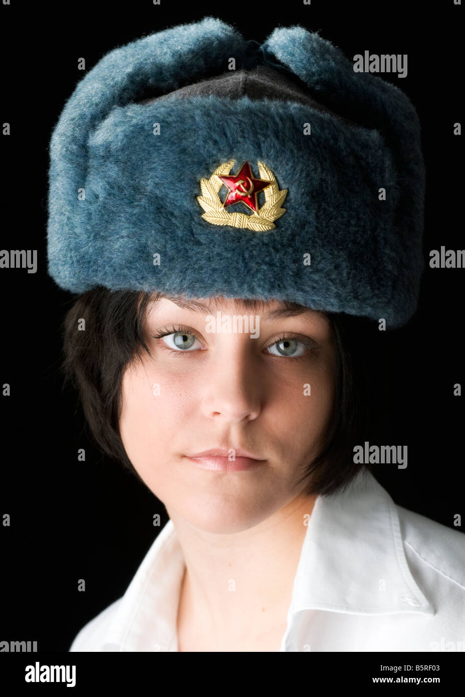 Beautiful blue eyed woman in Russian Ushanka hat with badge of the Soviet Union flag Stock Photo