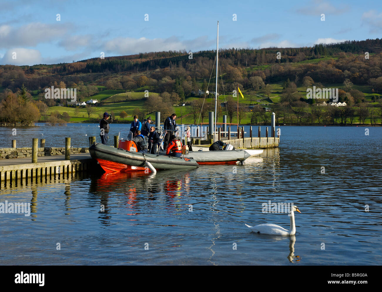 People boarding inflatable boat at a pier on Coniston lake, Lake District National Park, Cumbria, England UK Stock Photo