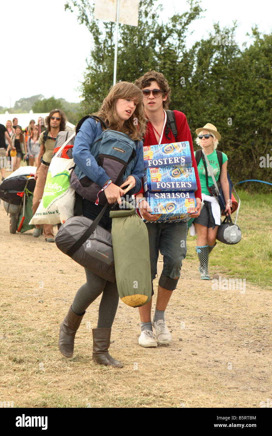 Glastonbury Festival June 2008 festival goers fans first day arrivals with heavy backpacks tents and sleeping bags beer arrive Stock Photo