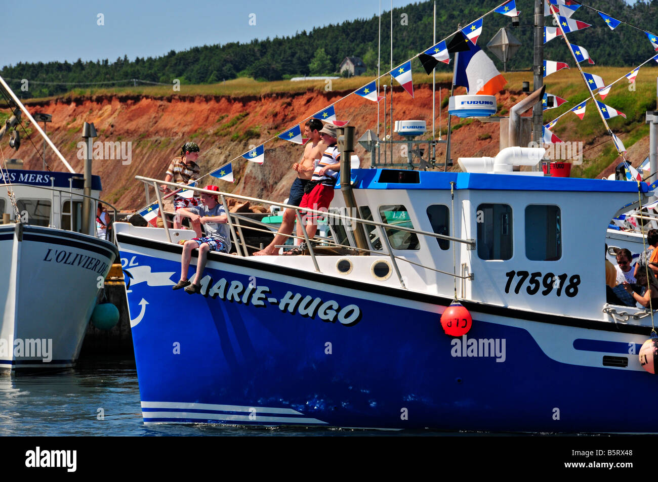 Acadian Flags on fishing boats celebrating the day of fishermen Iles de la Madeleine Quebec Stock Photo
