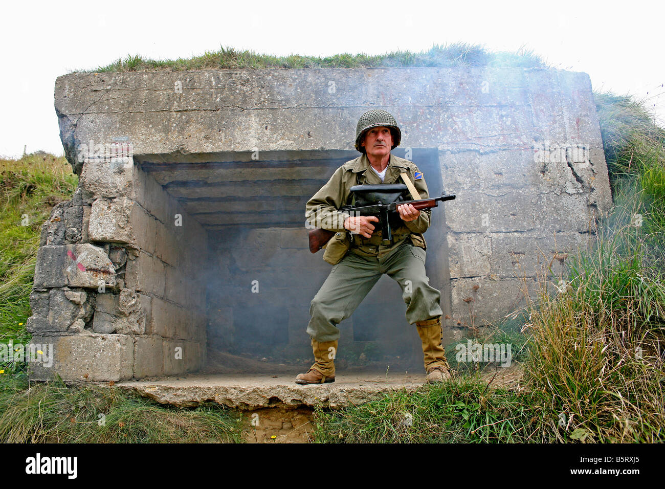 actor dressed as a  D Day U.S.Ranger storming a German bunker a Pointe du Hoc,Normandy,France Stock Photo