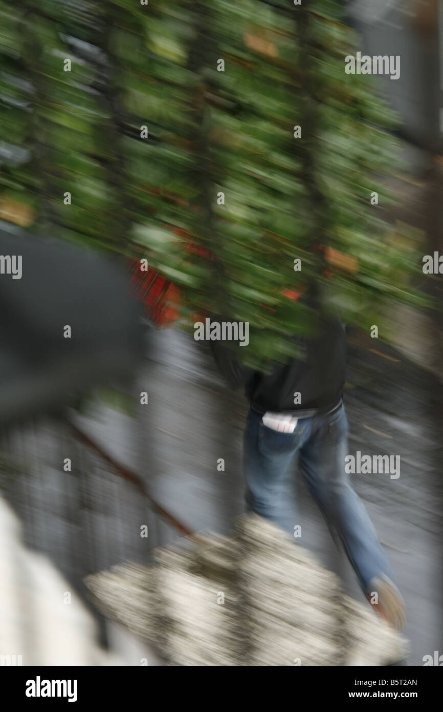 person running on pavement in rain in town Stock Photo