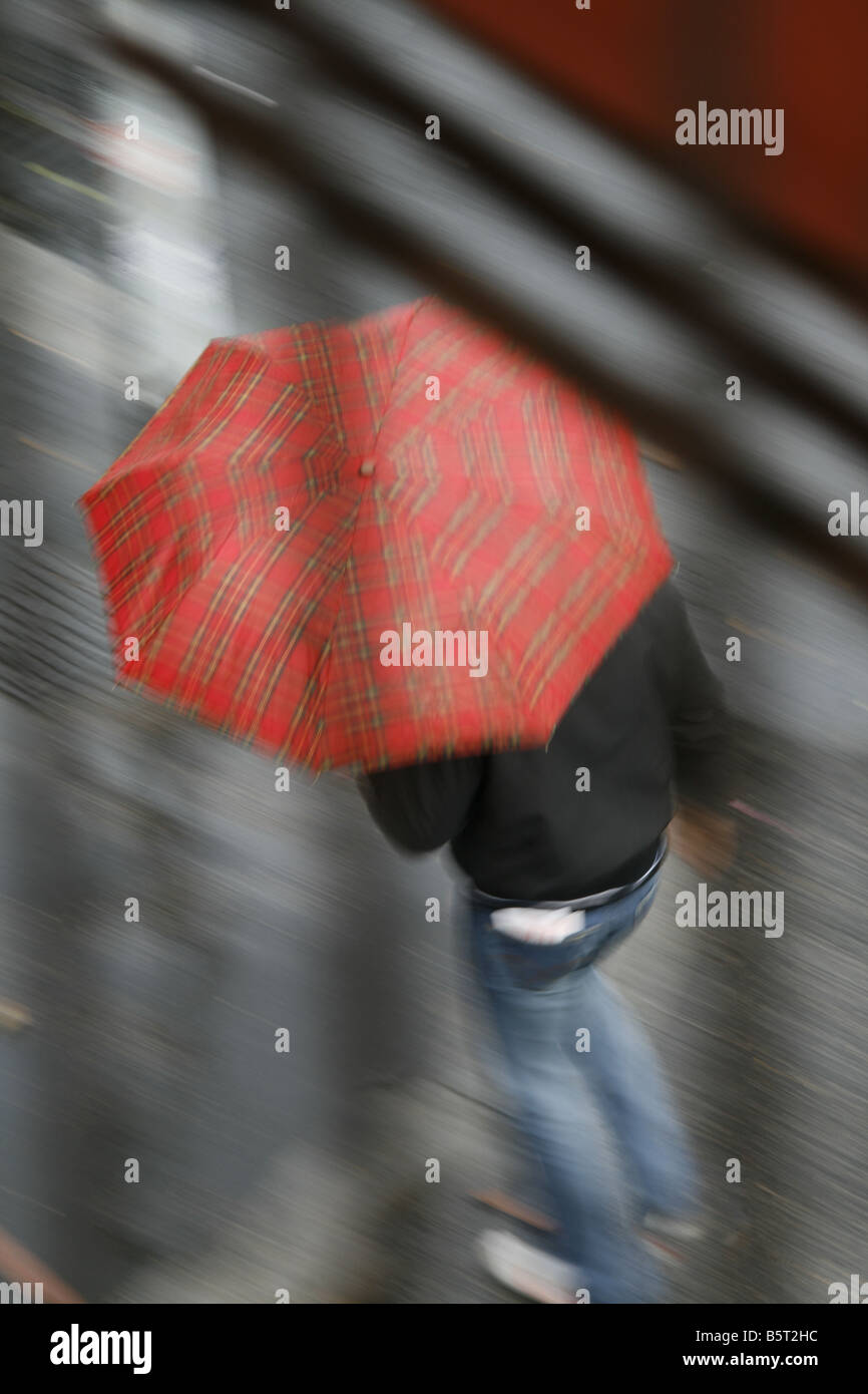 person with red umbrella walking in rain in town Stock Photo - Alamy