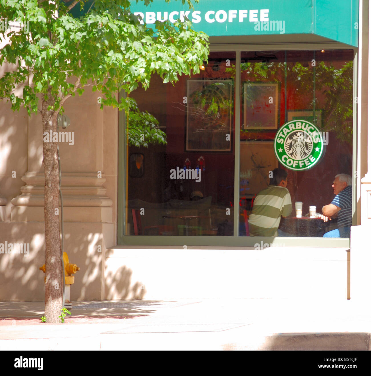 Starbucks with people talking inside Stock Photo