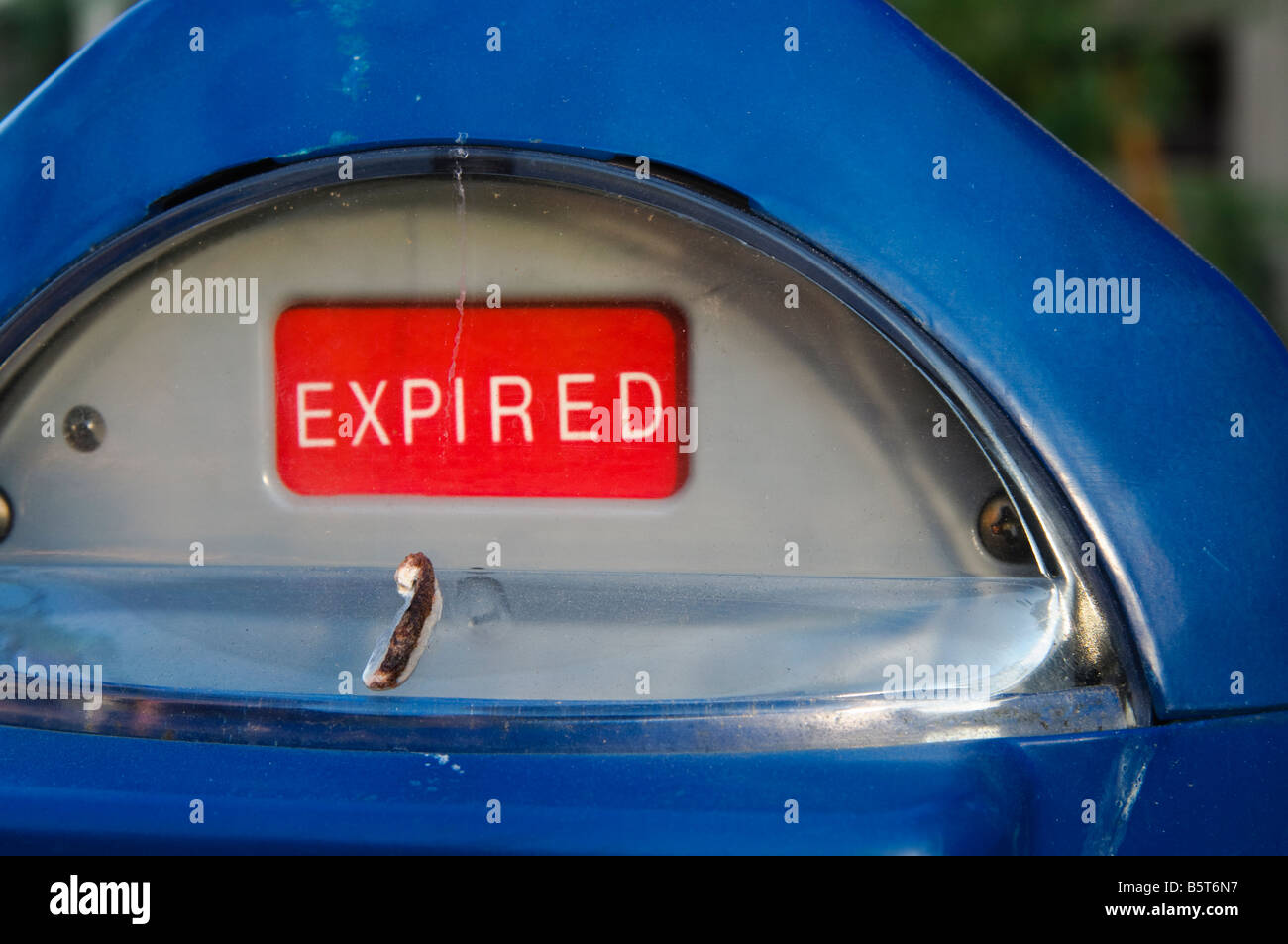 Bird poop on a blue expired parking meter parking ticket left by bird