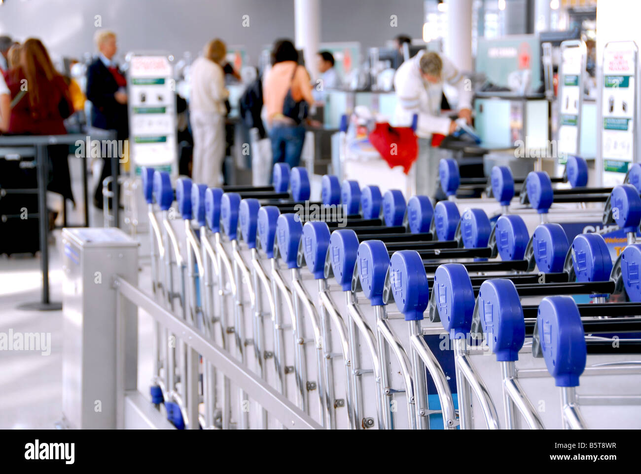 Luggage carts at modern international airport passengers at check in