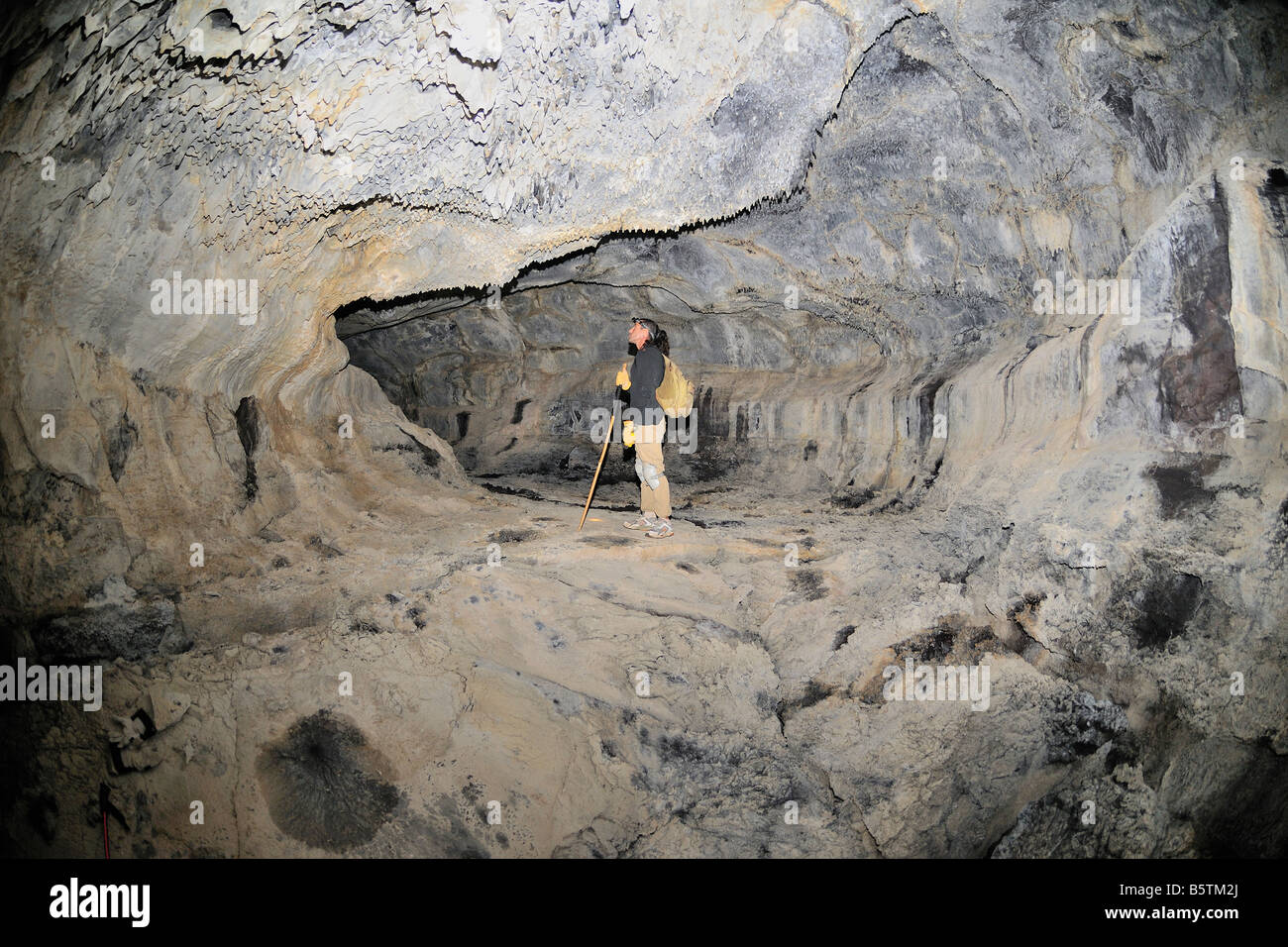 Hiker in one of the large lava tubes from the Hualalai volcano 1801 flow Kailau Kona The Big Island of Hawaii Stock Photo