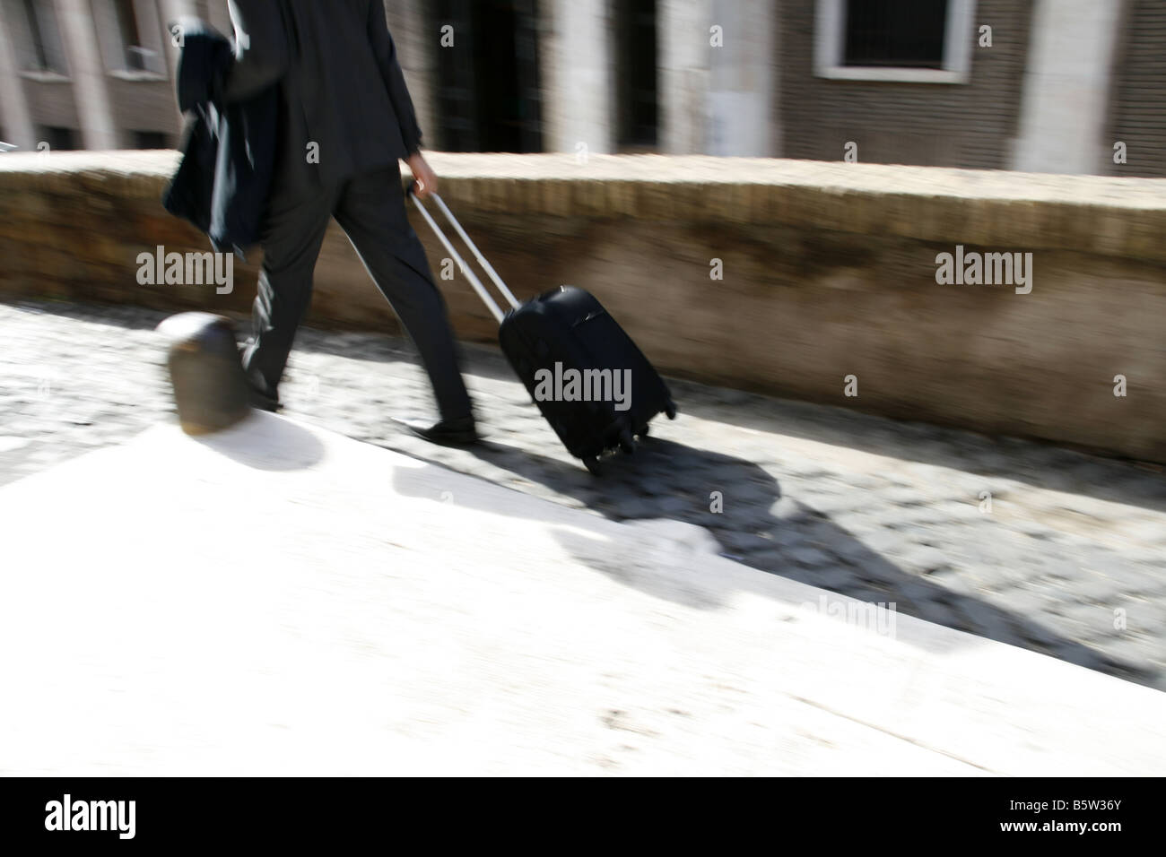 business man pulling trolley luggage case in town Stock Photo Alamy