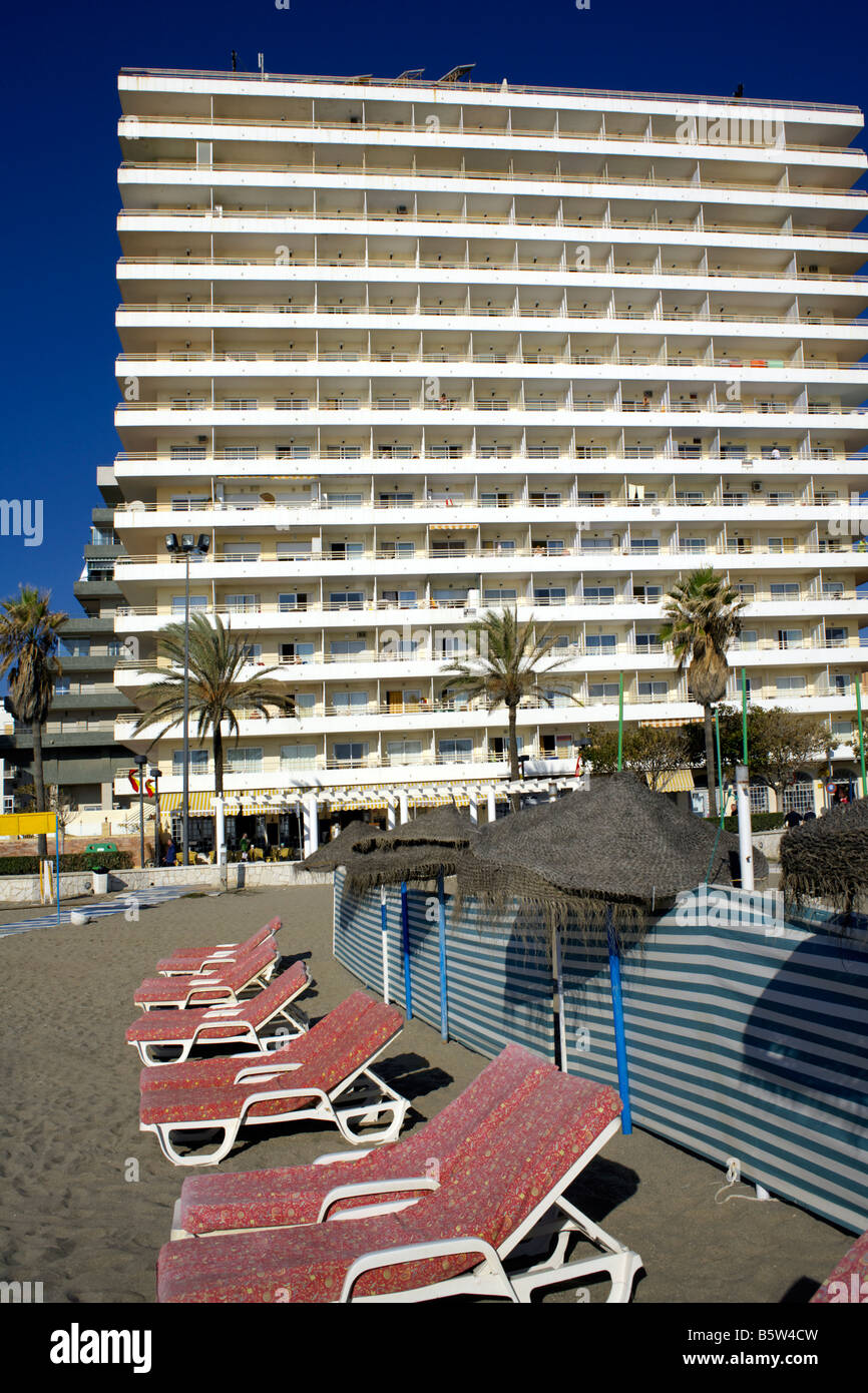 Sunbeds and parasols on a deserted beach, behind stands the Stella Maris Hotel, Passeio Maritimo, Fuengirola, Spain Stock Photo