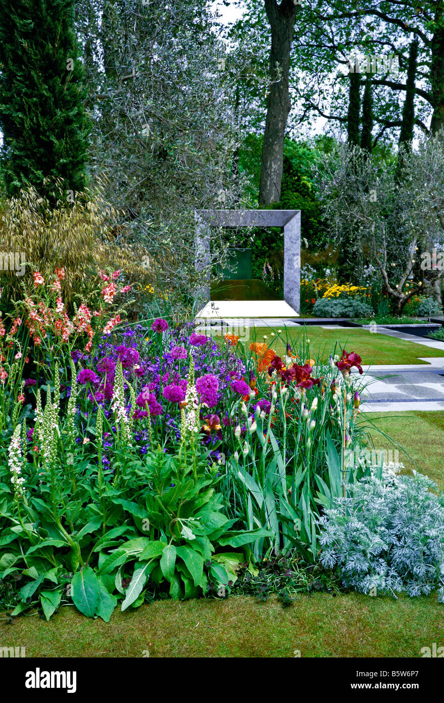 Colourful flowering Chelsea garden with abstract sculpture Stock Photo