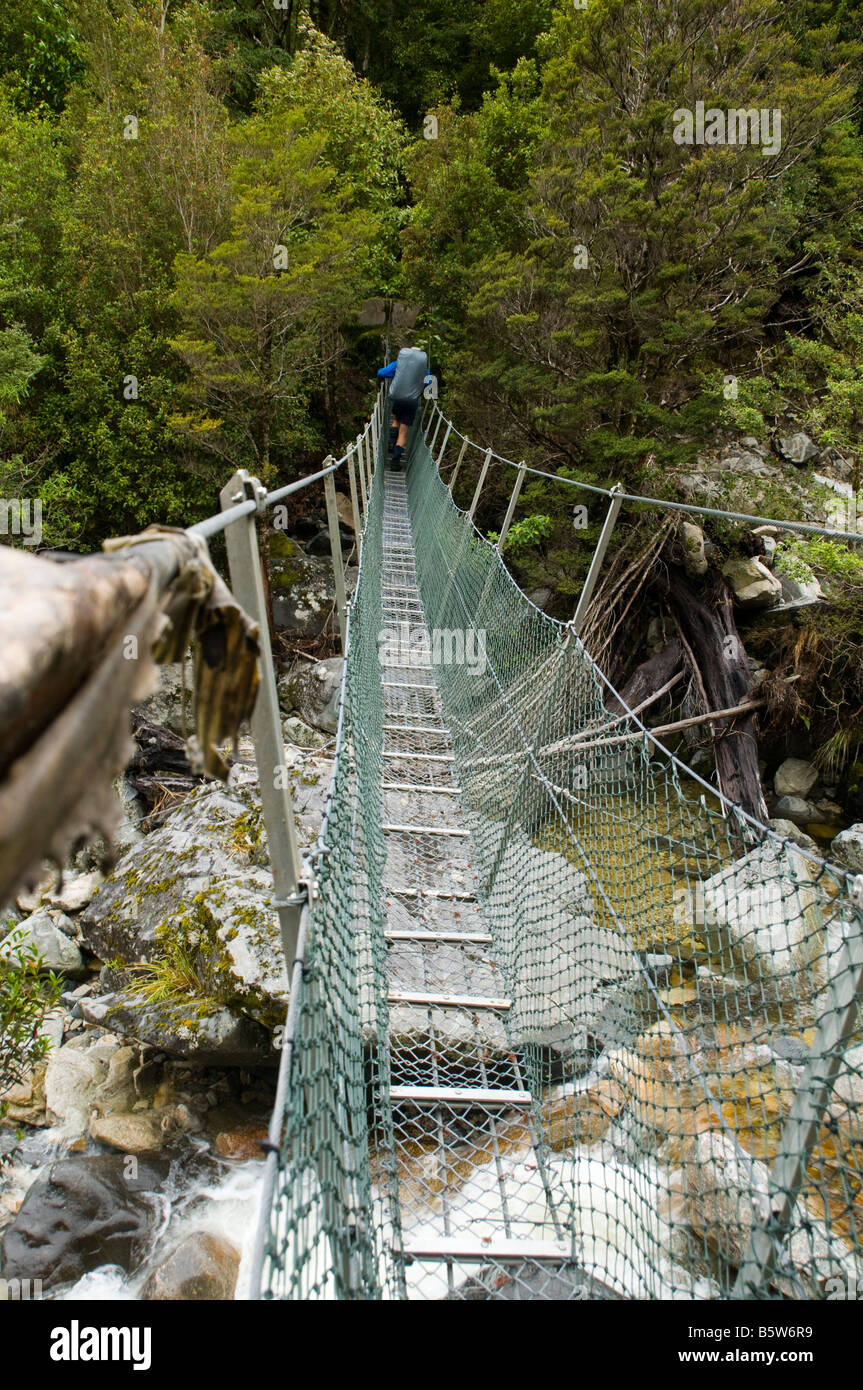 Crossing a swing suspension bridge, Wangapeka Track, South Island, New