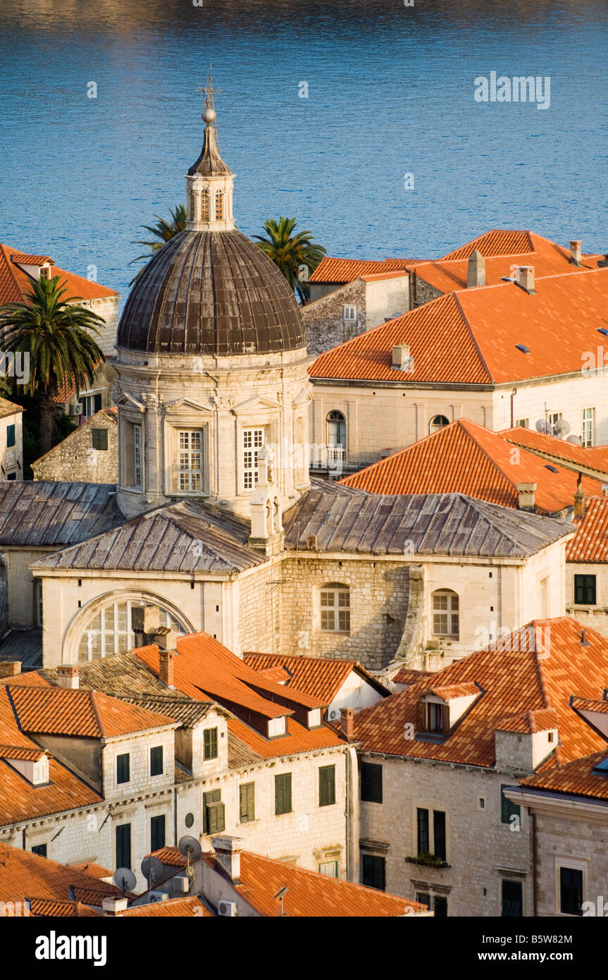 Dubrovnik Croatia Church tower rises above red roof tops in the historic old town with Adriatic Sea beyond at sunset Stock Photo