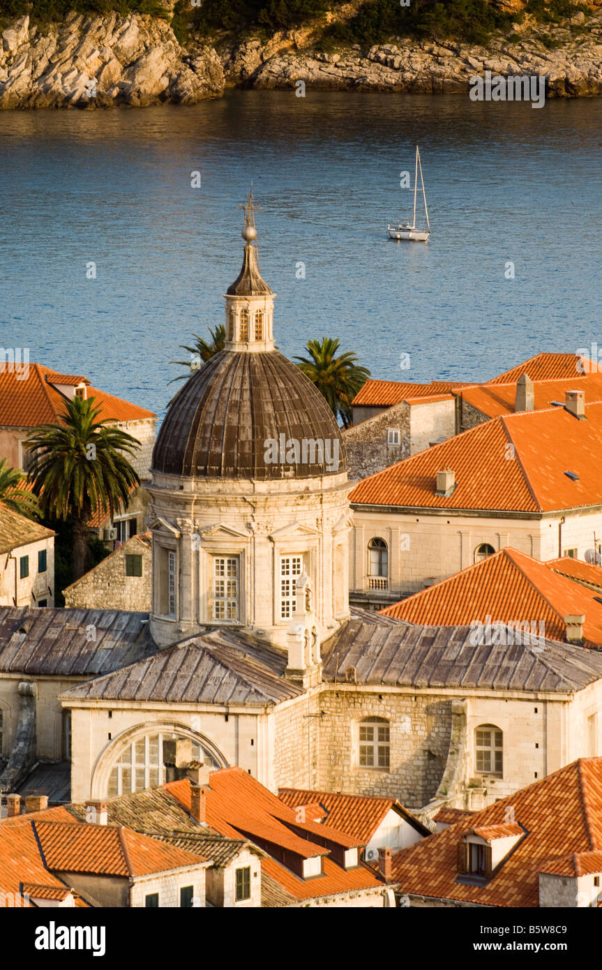 Dubrovnik Croatia Church tower rises above red roof tops in the historic old town with Adriatic Sea beyond at sunset Stock Photo