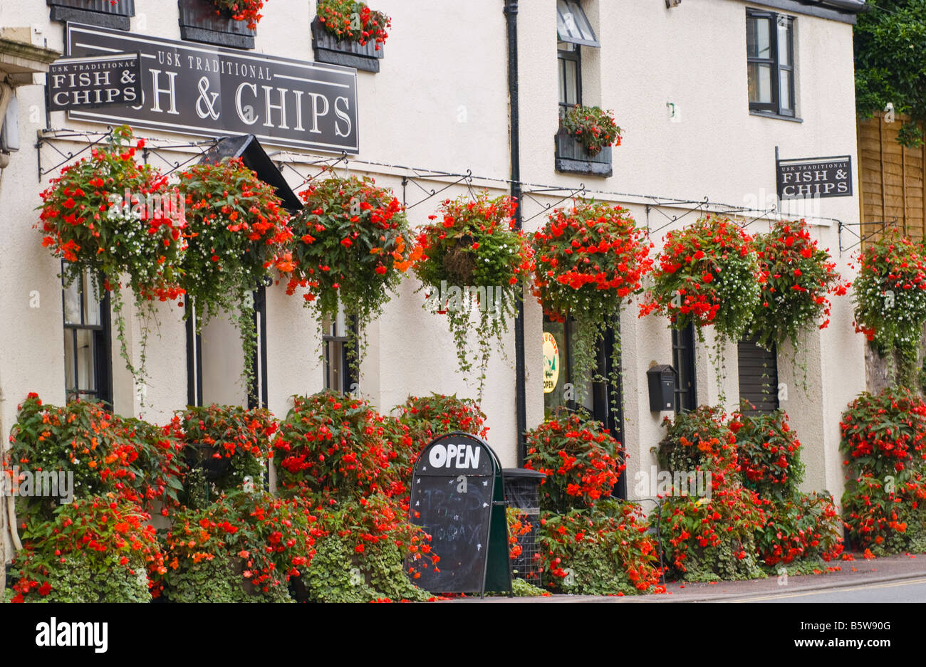 Fish and Chips shop with hanging flower baskets outside in rural town of Usk Monmouthshire South