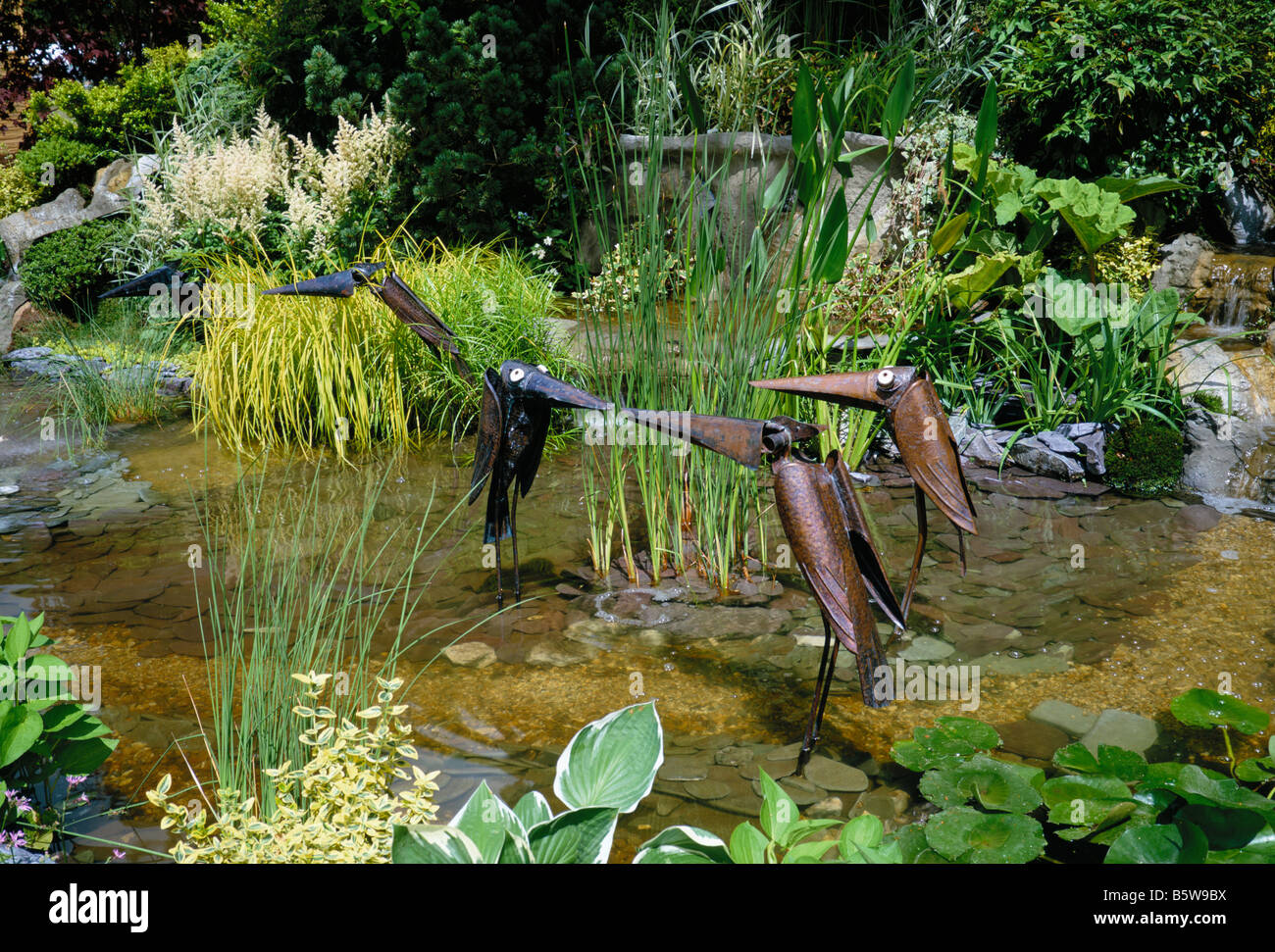Wildlife pond with decorative sculptured metal birds Stock Photo