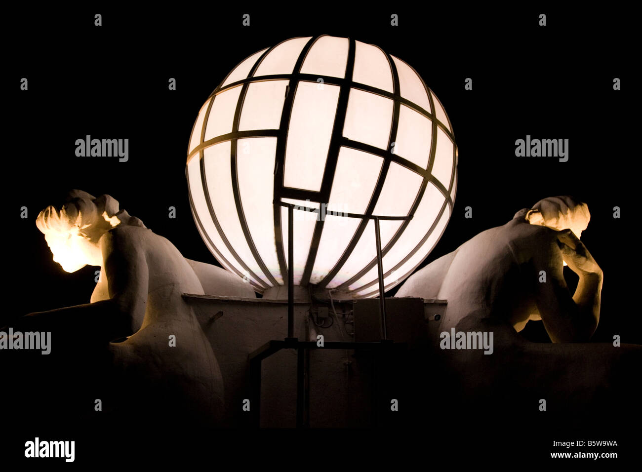 The globe and classical figures on top of the Grand Hotel Atlantic Kempinski are illuminated at night. Stock Photo